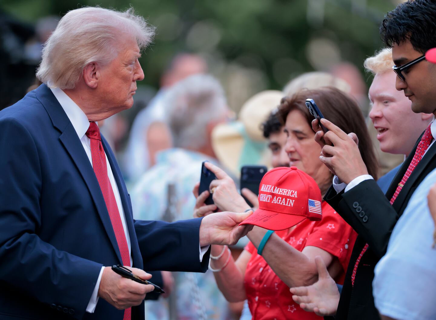 President Trump signed a hat as he greeted guests during the congressional picnic on the South Lawn of the White House on May 19.